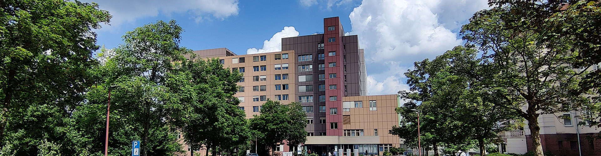 Bildungszentrum Pirmasens, modernes Ausbildungsgebäude des Städtischen Krankenhauses, umgeben von grünen Bäumen bei schönem Wetter.